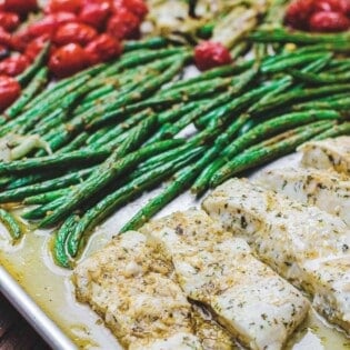 One Pan Baked Halibut Recipe | The Mediterranean Dish. Halibut fillet with green beans and cherry tomatoes baked in a delicious Mediterranean sauce with garlic, olive oil and lemon juice. Comes together in less than 30 mins! See the step-by-step on The Mediterranean Dish.