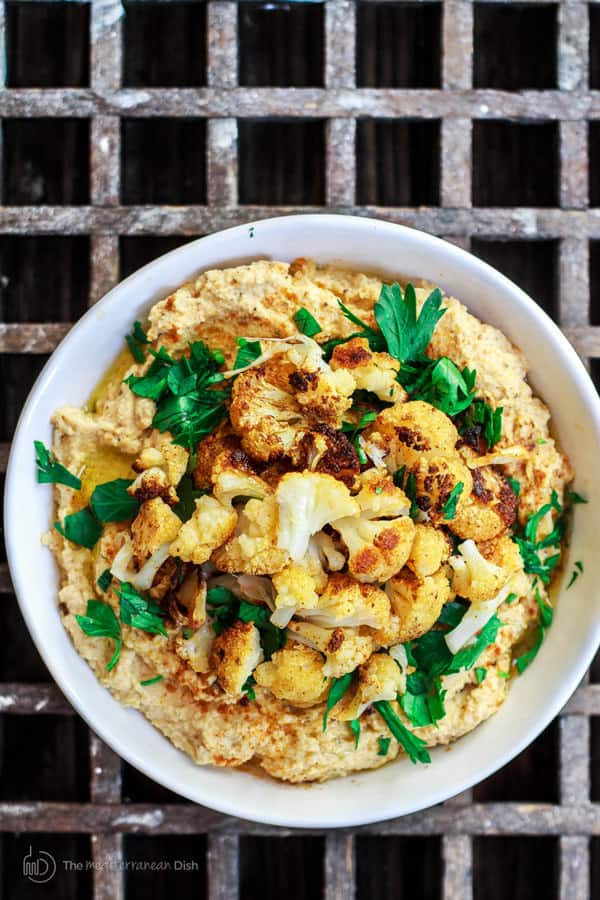 Roasted Cauliflower Tahini Dip garnished with additional roasted cauliflower and olive oil drizzle
