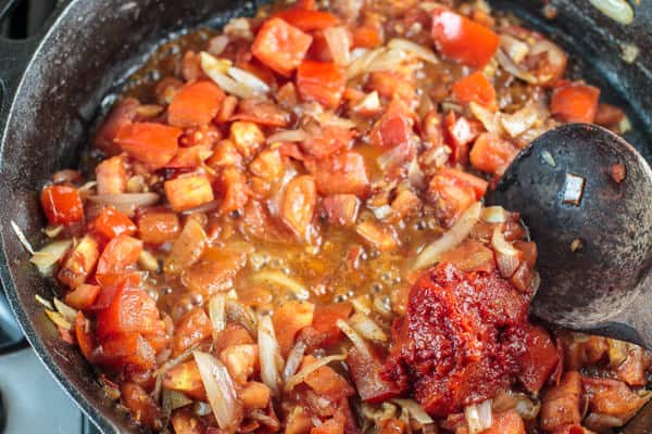 Harissa paste is added to the pan and cooked in with the onions