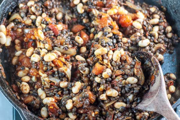 Lentils and white beans are added to the pan of Harissa paste and onions