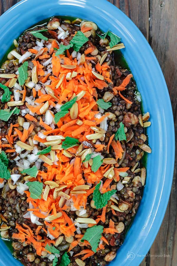 Platter containing Lentil Salad topped with carrots, sliced almond and fresh mint leaves