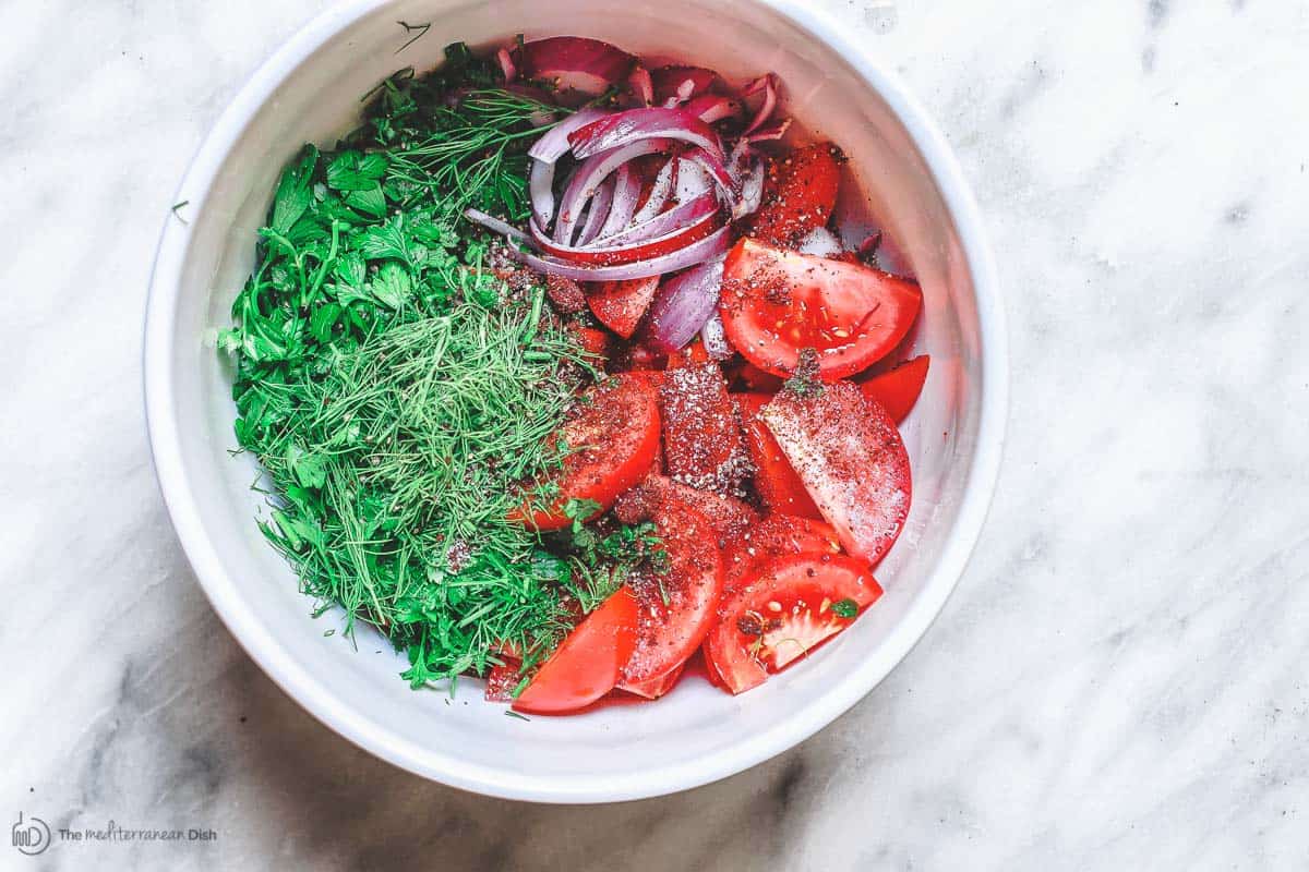 Tomato salad ingredients in mixing bowl