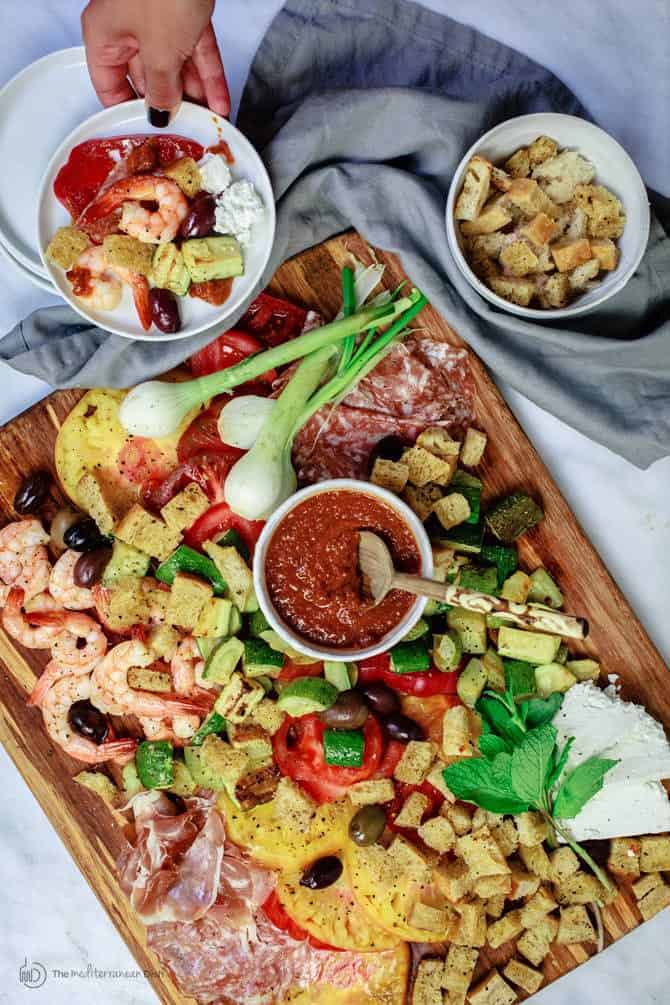Cutting board loaded with salad ingredients all laid out to be served