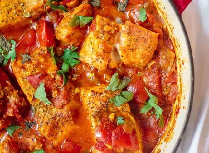 Fish fillet cooked with tomato sauce and served shakshuka style in a braiser