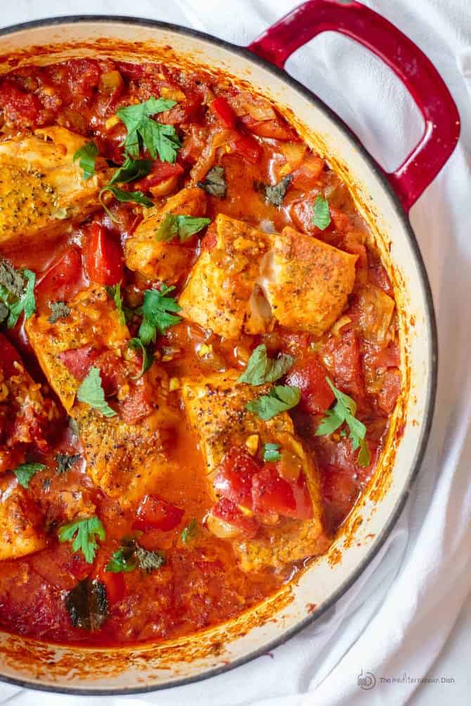 Fish fillet cooked with tomato sauce and served shakshuka style in a braiser