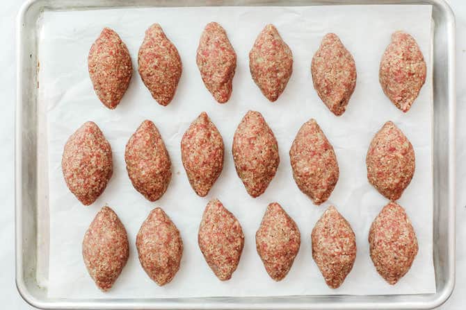 Stuffed Kibbeh shells lined on a baking sheet