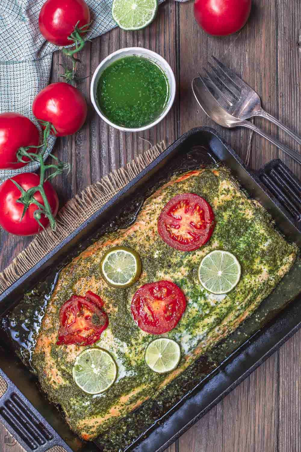 Baked Salmon Served with extra garlic cilantro sauce on side and more tomatoes