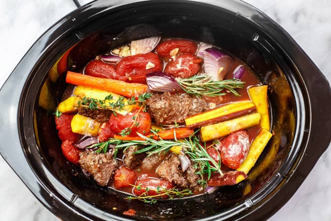 Crock Pot Italian Beef Stew Recipe | The Mediterranean Dish. This is a family favorite! Beef stew that's been slow cooked to tender perfection in a special wine broth with loads of carrots, mushrooms and aromatics. Packed with flavor from garlic, onions, and fresh herbs. Best part, it takes only 15 minutes to prep, and the crock pot does all the heavy lifting. This is the prefect beef stew! A must-try from TheMediterraneanDish.com