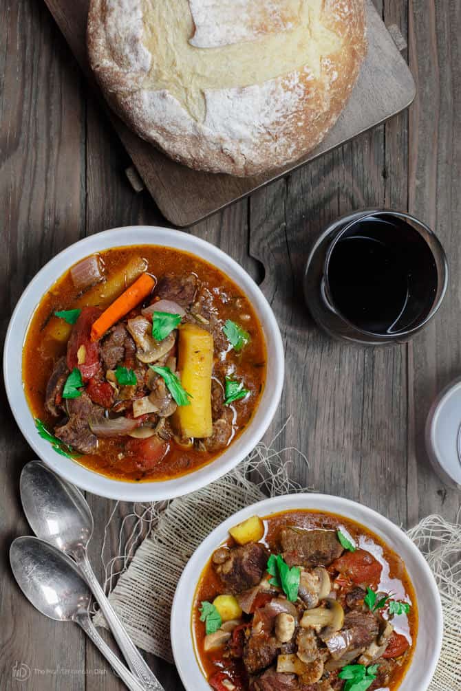 Crock Pot Italian Beef Stew Recipe | The Mediterranean Dish. This is a family favorite! Beef stew that's been slow cooked to tender perfection in a special wine broth with loads of carrots, mushrooms and aromatics. Packed with flavor from garlic, onions, and fresh herbs. Best part, it takes only 15 minutes to prep, and the crock pot does all the heavy lifting. This is the prefect beef stew! A must-try from TheMediterraneanDish.com