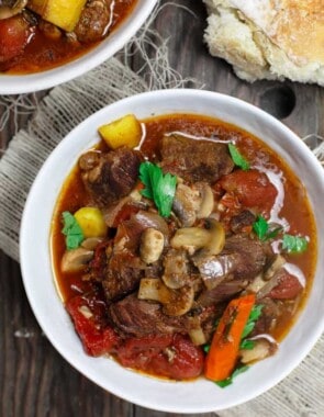 Crock Pot Italian Beef Stew Recipe | The Mediterranean Dish. This is a family favorite! Beef stew that's been slow cooked to tender perfection in a special wine broth with loads of carrots, mushrooms and aromatics. Packed with flavor from garlic, onions, and fresh herbs. Best part, it takes only 15 minutes to prep, and the crock pot does all the heavy lifting. This is the prefect beef stew! A must-try from TheMediterraneanDish.com