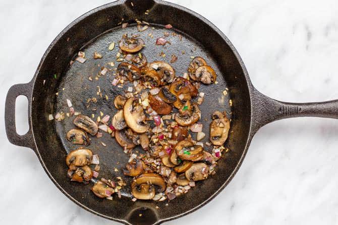 Skillet containing mushrooms, onions and garlic.