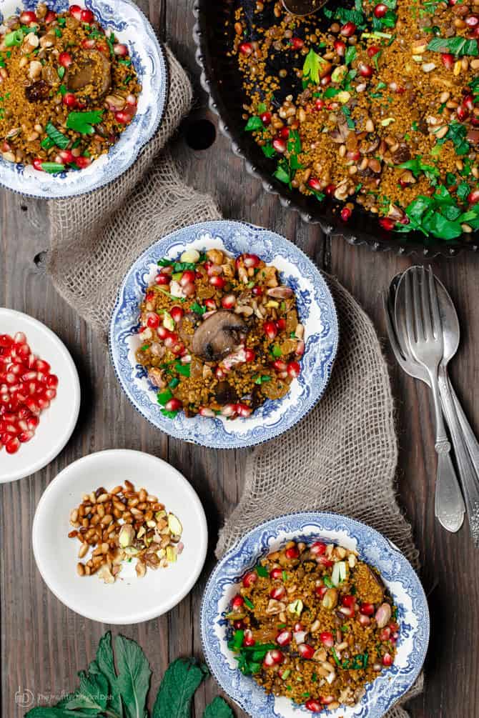 Couscous topped with pomegranate seeds and lentils. Side of extra pomegranate seeds and nuts for additional texture.