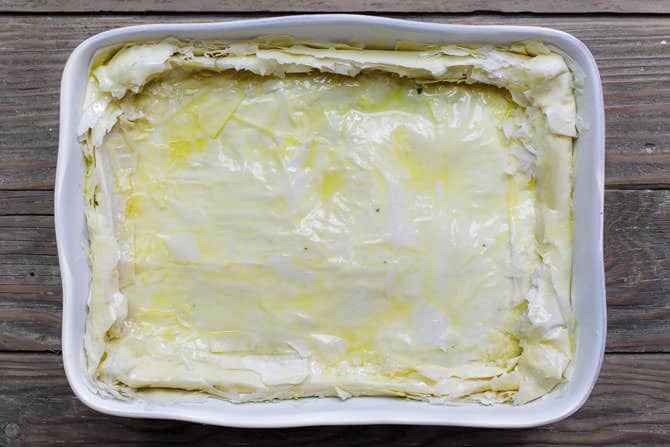 Uncooked spanakopita fully assembled in casserole dish