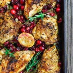 Baked Cranberry Chicken with Rosemary and lemon halves in a large sheet pan