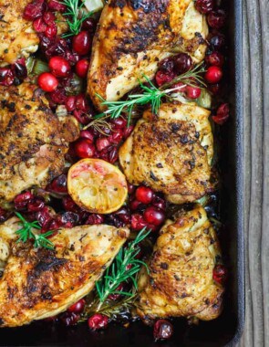 Baked Cranberry Chicken with Rosemary and lemon halves in a large sheet pan