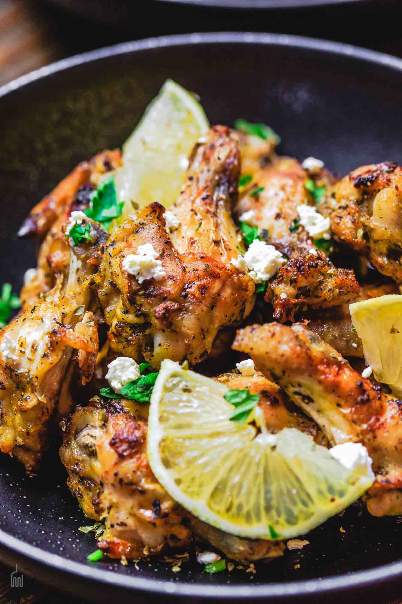 Delicious Greek chicken wings topped with fresh feta cheese and lemon wedge