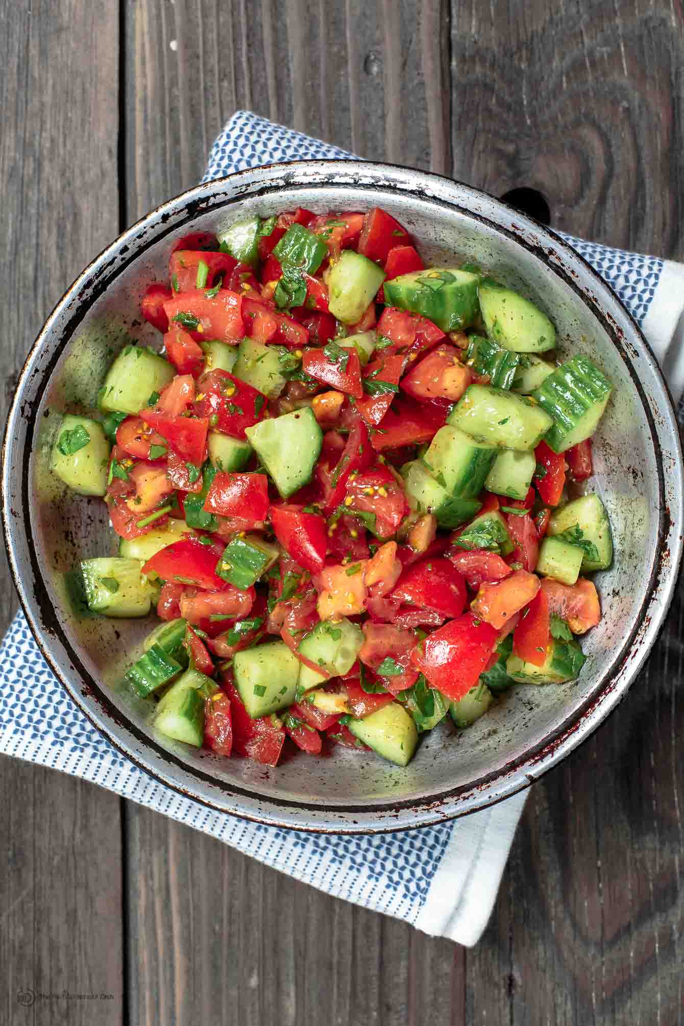 Mediterranean salad with tomatoes, cucumbers, and parsley in a bowl