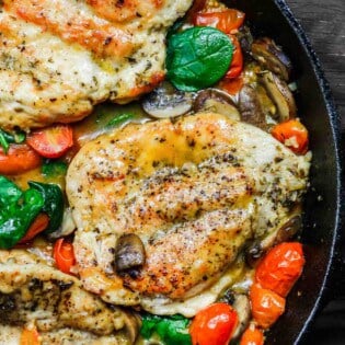 30-Minute Italian Skillet Chicken Recipe with Tomatoes and Mushrooms | The Mediterranean Dish. Flavor packed chicken breasts cooked in white wine with mushrooms, tomatoes and more! The perfect weeknight dinner in minutes! See the recipe on TheMediterraneanDish.com