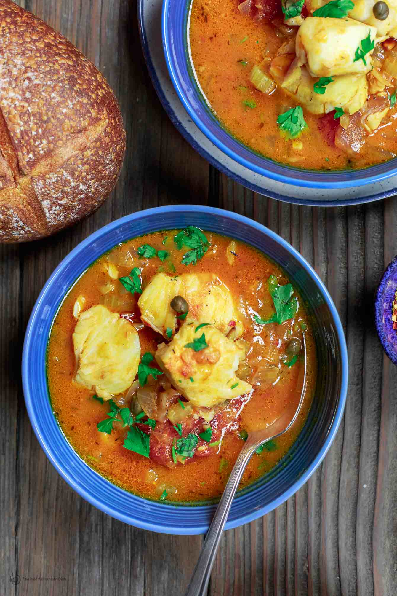 Sicilian Fish Stew Recipe | The Mediterranean Dish. Italian comfort in a bowl! My favorite! Fish fillet pieces cooked in a white wine and tomato broth with garlic, capers and more! Super easy and quick recipe. See it on TheMediterraneanDish.com