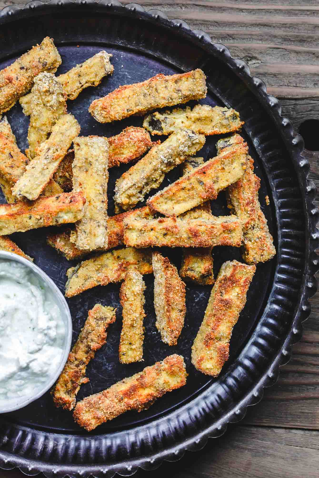 Plate with crispy, baked eggplant fries served with Greek Tzatziki Sauce