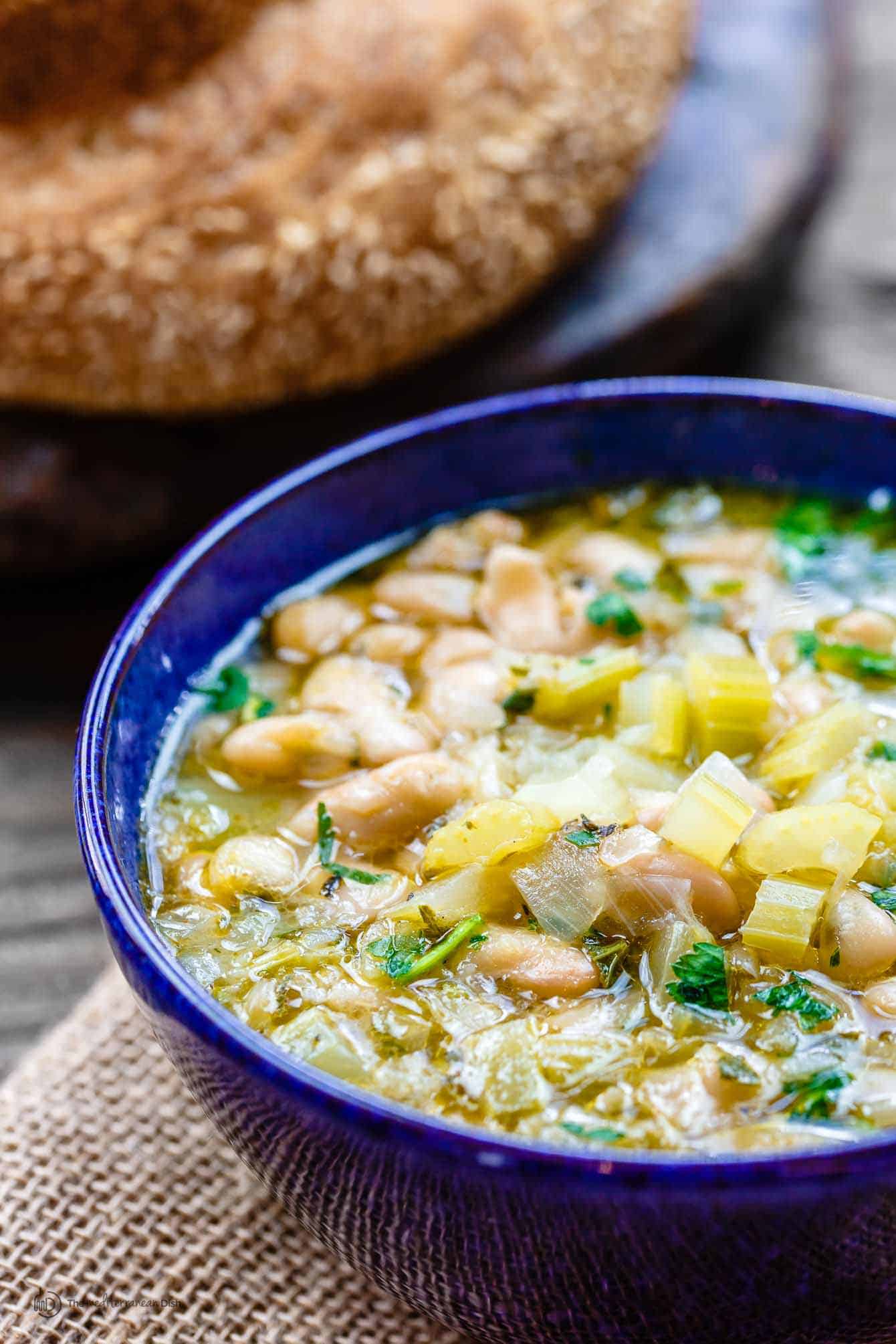 Easy Greek Bean Soup (Fasolada) | The Mediterranean Dish. Simple, flavor-packed Greek soup with white beans, celery, Mediterranean spices and aromatics. A satisfying weeknight dinner for a family on a budget! See the recipe on TheMediterraneanDish.com