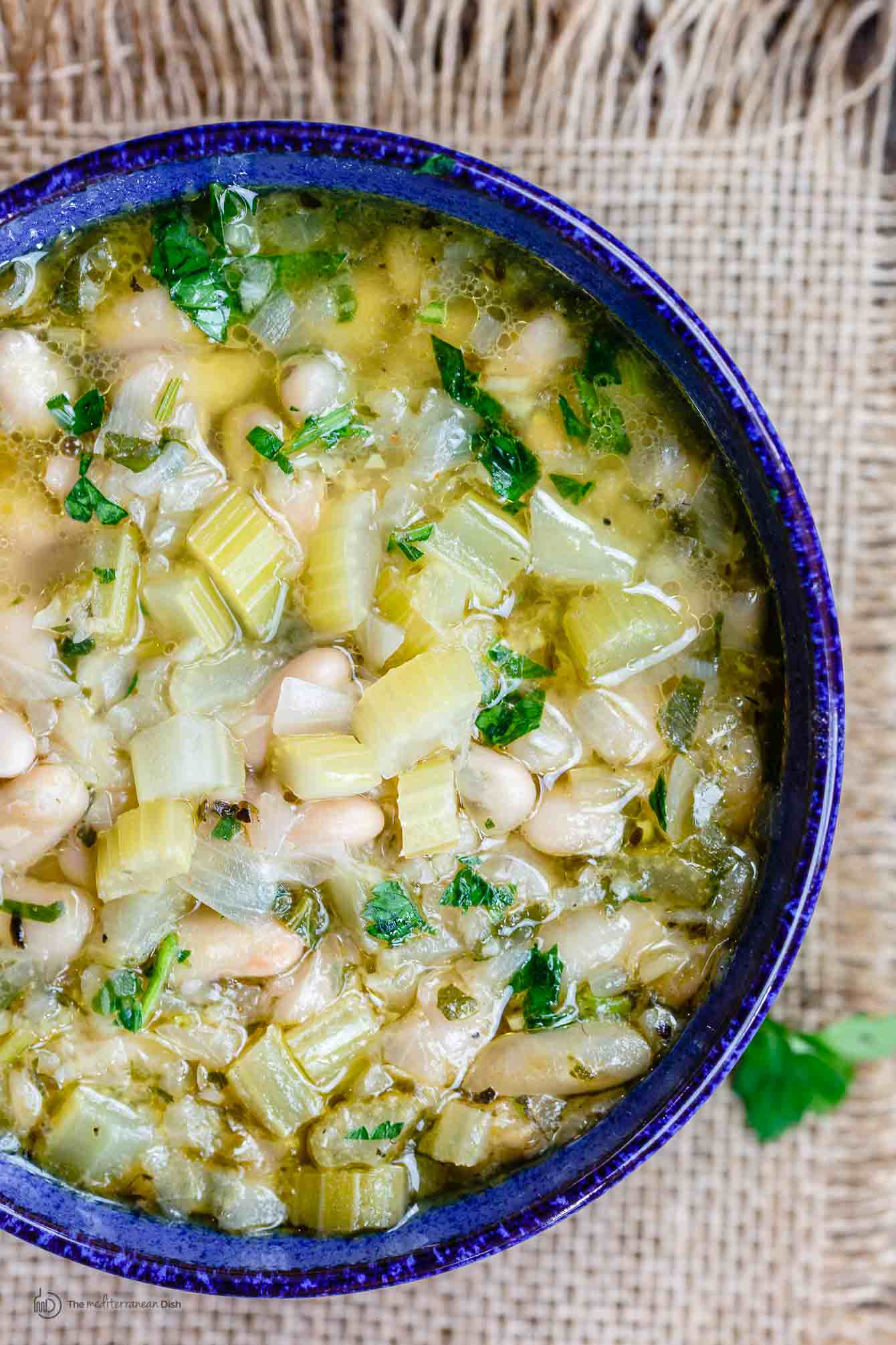 Easy Greek Bean Soup (Fasolada) | The Mediterranean Dish. Simple, flavor-packed Greek soup with white beans, celery, Mediterranean spices and aromatics. A satisfying weeknight dinner for a family on a budget! See the recipe on TheMediterraneanDish.com