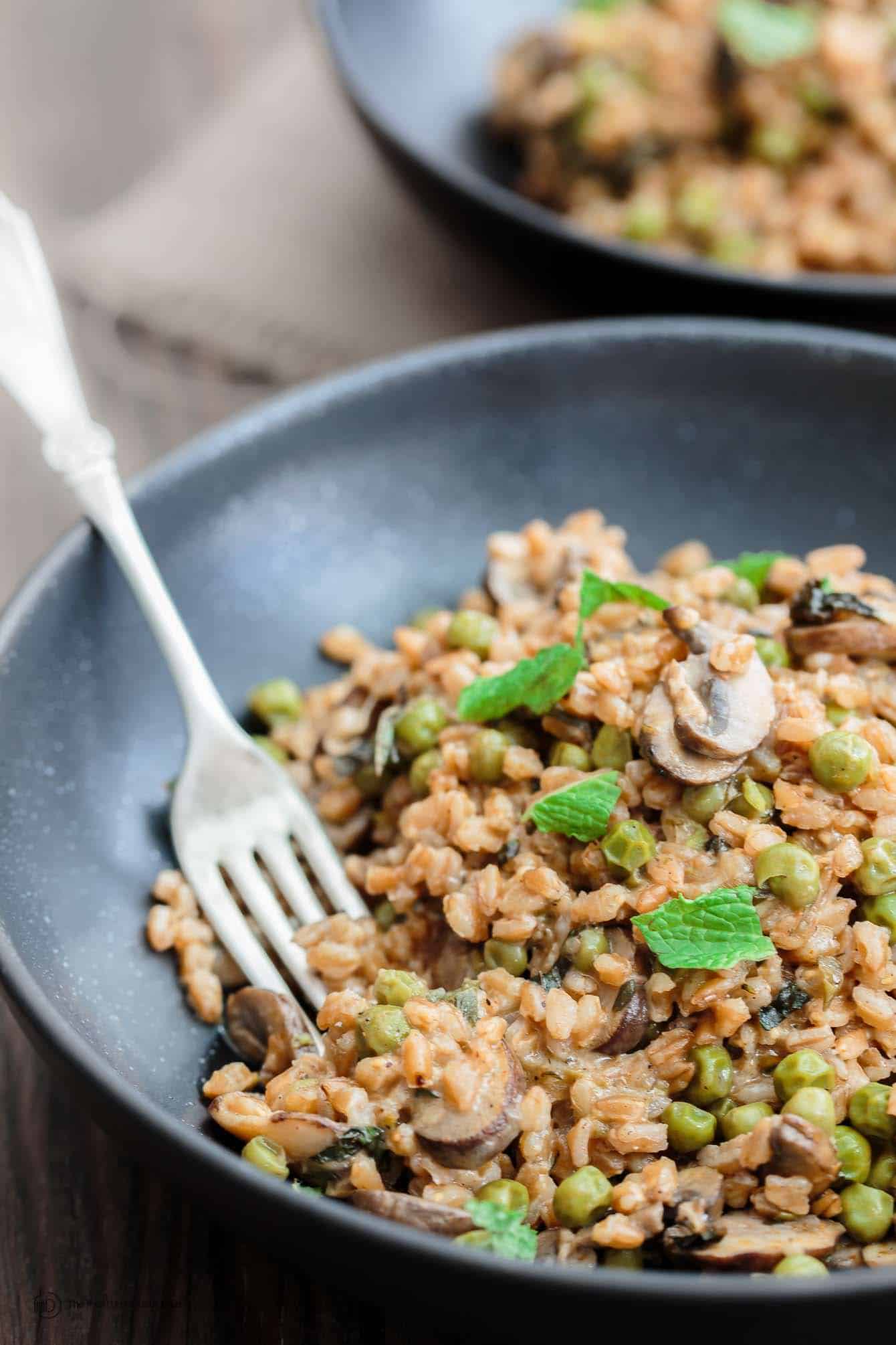 One-Pan Farro Recipe with Mushrooms and Peas | The Mediterranean Dish. This is my family's favorite farro recipe! Easy and tasty farro recipe made Mediterranean-style with mushrooms, peas, green onions, garlic, fresh herbs and more! So little work too! See the recipe on TheMediterraneanDish.com