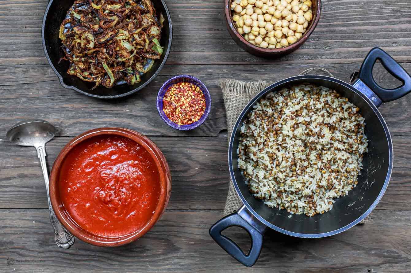 Egyptian Koshari Recipe | The Mediterranean Dish. Hands down a family favorite. A comforting bowl of spiced lentils and rice with chickpeas, tiny pasta, and tomato sauce. Topped with thin crispy onion rings. A tasty, budget friendly, vegan recipe! See it on TheMediterraneanDish.com