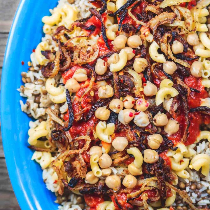 Egyptian Koshari Recipe | The Mediterranean Dish. Hands down a family favorite. A comforting bowl of spiced lentils and rice with chickpeas, tiny pasta, and tomato sauce. Topped with thin crispy onion rings. A tasty, budget friendly, vegan recipe! See it on TheMediterraneanDish.com