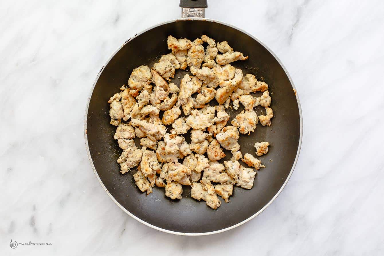 Chicken sausage being cooked in a skillet