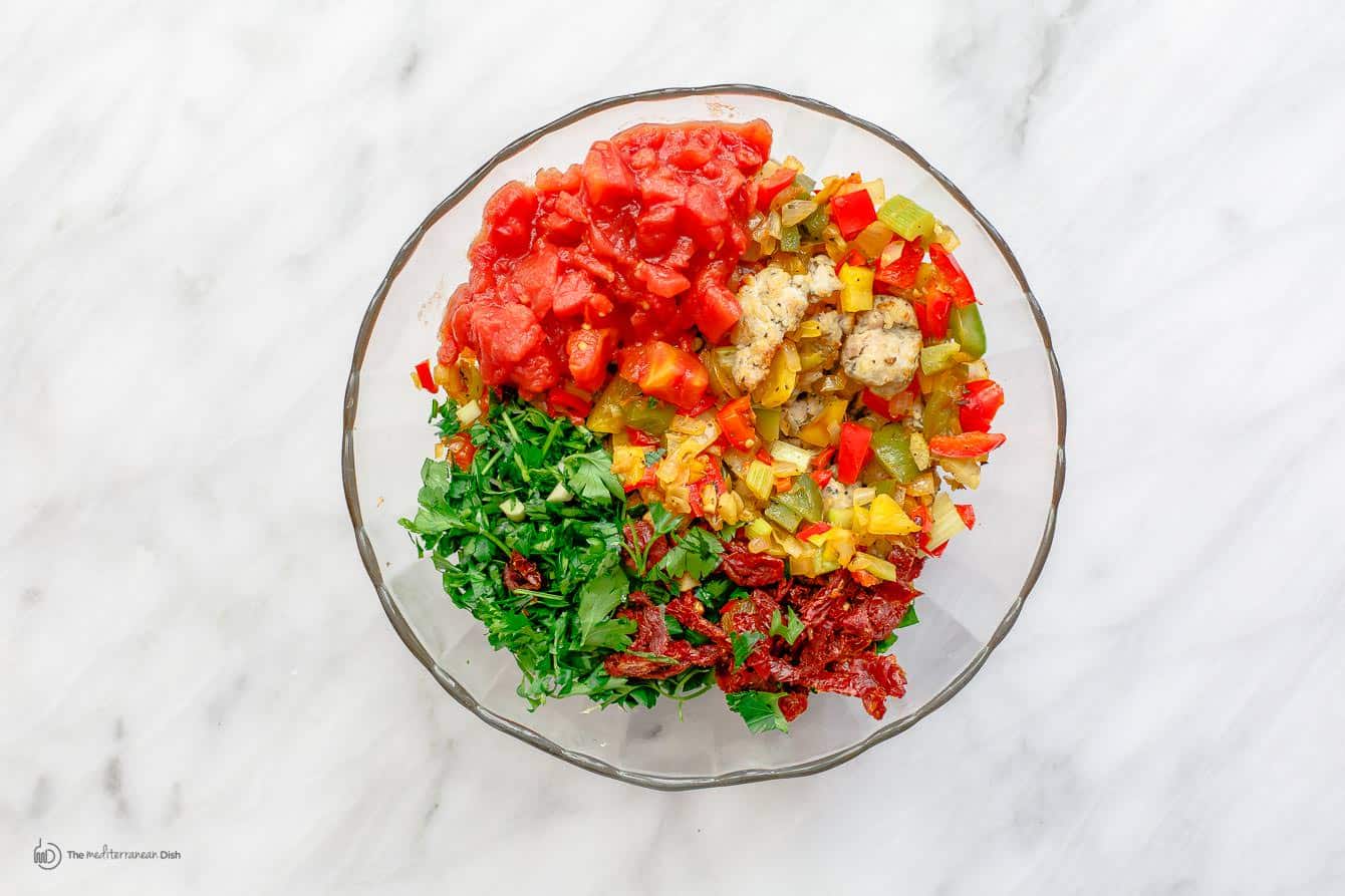 Sausage, vegetables, sundried tomato bits, parsley, and diced tomato combined in a bowl