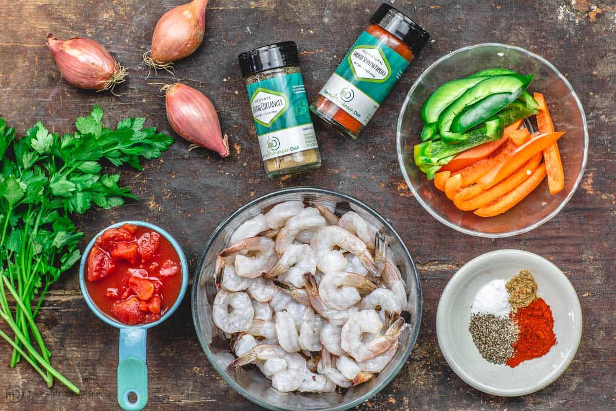 Ingredients for shrimp recipe including shrimp, spices, bell peppers, tomatoes and parsley