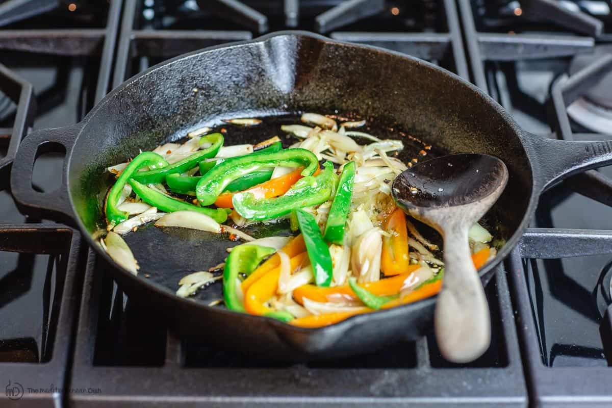 Bell peppers are added to cook with shallots and garlic