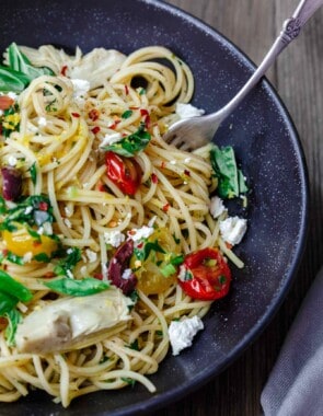 Simple Mediterranean Olive Oil Pasta | The Mediterranean Dish. A favorite and super light pasta dish where the sauce is quality extra virgin olive oil with garlic. Adding parsley, tomatoes and couple more Mediterranean flavors makes this dish the perfect lunch, side, or even light supper. An easy Mediterranean diet recipe. Find it on TheMediterraneanDish.com