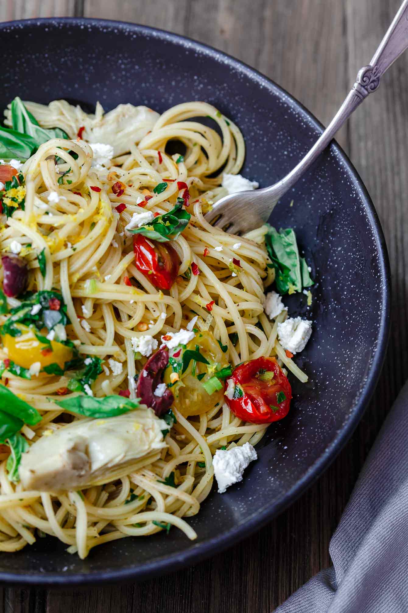 Simple Mediterranean Olive Oil Pasta | The Mediterranean Dish. A favorite and super light pasta dish where the sauce is quality extra virgin olive oil with garlic. Adding parsley, tomatoes and couple more Mediterranean flavors makes this dish the perfect lunch, side, or even light supper. An easy Mediterranean diet recipe. Find it on TheMediterraneanDish.com