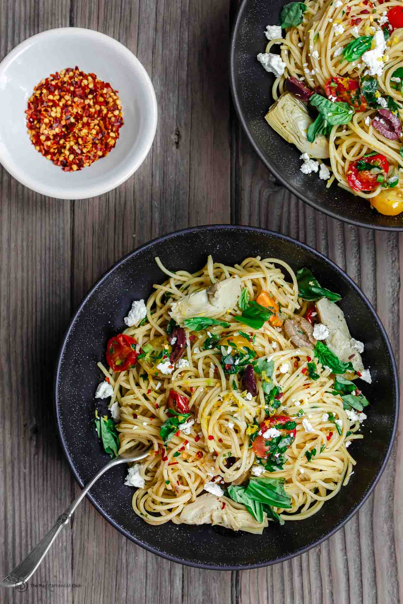 Simple Mediterranean Olive Oil Pasta | The Mediterranean Dish. A favorite and super light pasta dish where the sauce is quality extra virgin olive oil with garlic. Adding parsley, tomatoes and couple more Mediterranean flavors makes this dish the perfect lunch, side, or even light supper. An easy Mediterranean diet recipe. Find it on TheMediterraneanDish.com