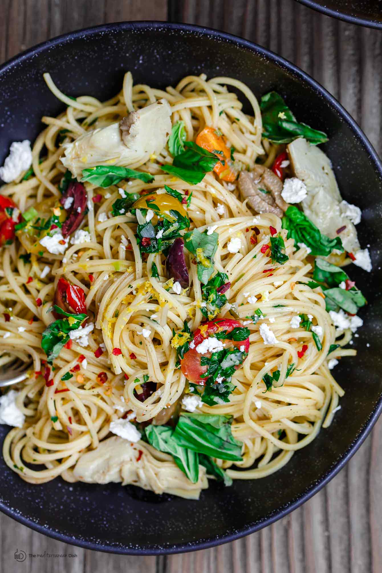 Simple Mediterranean Olive Oil Pasta | The Mediterranean Dish. A favorite and super light pasta dish where the sauce is quality extra virgin olive oil with garlic. Adding parsley, tomatoes and couple more Mediterranean flavors makes this dish the perfect lunch, side, or even light supper. An easy Mediterranean diet recipe. Find it on TheMediterraneanDish.com