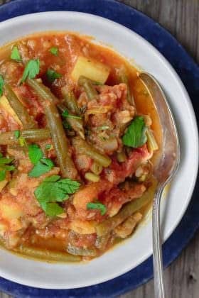 Greek Green Beans (Fasolakia) | The Mediterranean Dish. Braised Greek green beans with tomatoes, olive oil, aromatics and spices. Tender green beans, so velvety in texture. Satisfying and every bit flavor-packed. A healthy vegan entree or side dish that is so simple to make. Get the recipe on TheMediterraneanDish.com