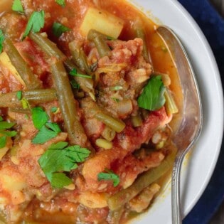 Greek Green Beans (Fasolakia) | The Mediterranean Dish. Braised Greek green beans with tomatoes, olive oil, aromatics and spices. Tender green beans, so velvety in texture. Satisfying and every bit flavor-packed. A healthy vegan entree or side dish that is so simple to make. Get the recipe on TheMediterraneanDish.com