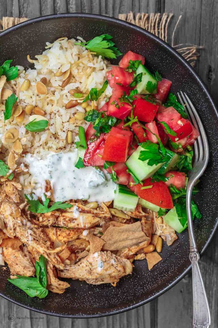 Lebanese Chicken Fatteh Dinner Bowls | The Mediterranean Dish. Flavor-packed Lebanese chicken recipe with toasted pita, rice and a simple Mediterranean salad all in one bowl. Check out the full recipe on TheMediterraneanDish.com