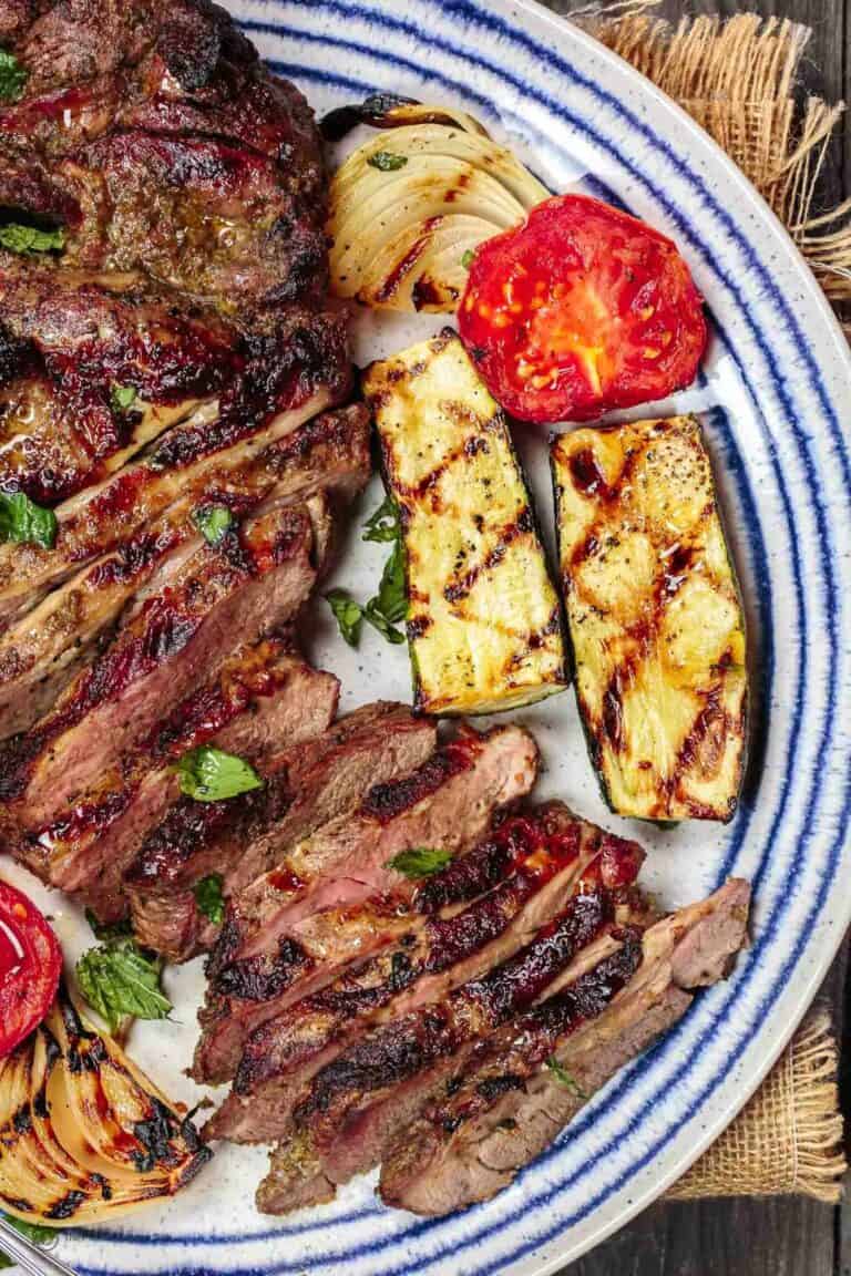 Mediterranean Grilled Lamb Recipe with Mint Pesto | The Mediterranean Dish. Garlic-herb marinated leg of lamb, tenderized and grilled to perfection! Plus mint pesto or Greek Tzatziki sauce and favorite Mediterranean summer sides and salads! See it on TheMediterraneanDish.com