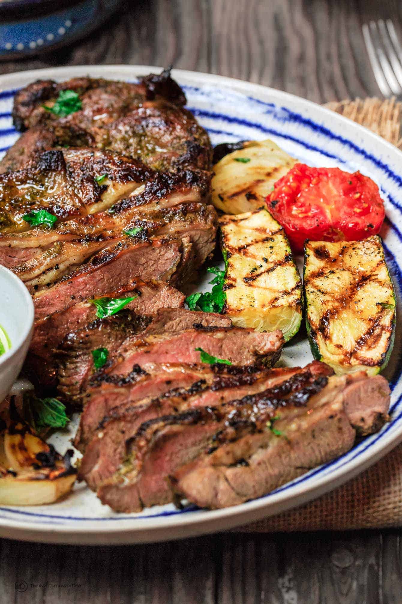 Plated Lamb served with grilled tomatoes and zucchini