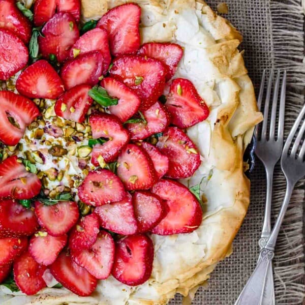 Feta Strawberry Tart with Fillo Crust | The Mediterranean Dish. A gorgeous sweet and savory strawberry tart with feta cheese, pistachio, basil and balsamic reduction! The flaky fillo (phyllo) crust takes it to a whole level of tasty! Easy recipe with step-by-step tutorial from TheMediterraneanDish.com