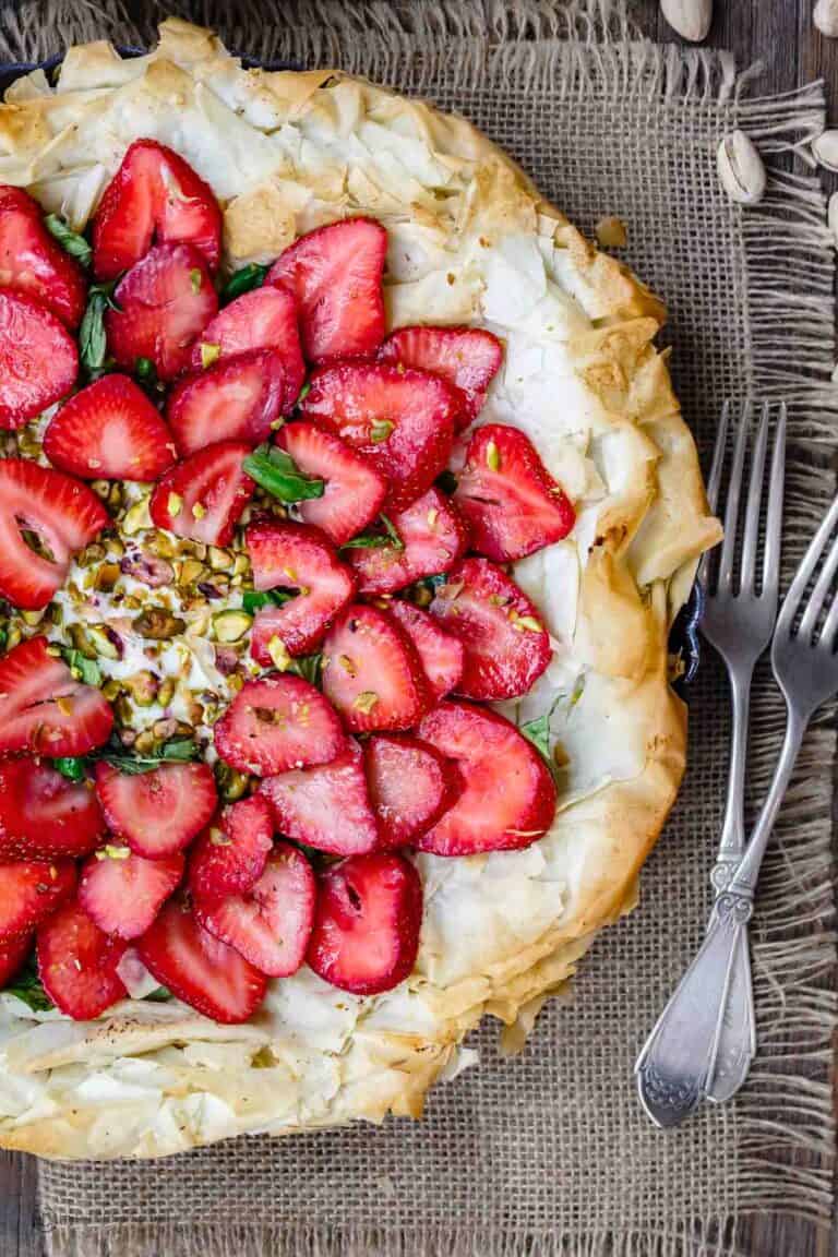 Feta Strawberry Tart with Fillo Crust | The Mediterranean Dish. A gorgeous sweet and savory strawberry tart with feta cheese, pistachio, basil and balsamic reduction! The flaky fillo (phyllo) crust takes it to a whole level of tasty! Easy recipe with step-by-step tutorial from TheMediterraneanDish.com