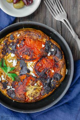 Open-Faced Greek Omelet Recipe with Tomatoes | The Mediterranean Dish. A simple Greek omelet or Fritatta with tomatoes, a sprinkle of feta cheese, fresh mint and favorite Mediterranean spices. This Greek omelet makes an excellent quick vegetarian dinner as well! See the recipe on TheMediterraneanDish.com