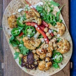 Mediterranean Vegan Wraps with Cauliflower and Tahini | The Mediterranean Dish. Satisfying vegan wraps with a Mediterranean twist. With za'atar roasted cauliflower, homemade tahini sauce, and a peppery arugula salad. A flavor-packed meatless dinner! See the recipe on TheMediterraneanDish.com