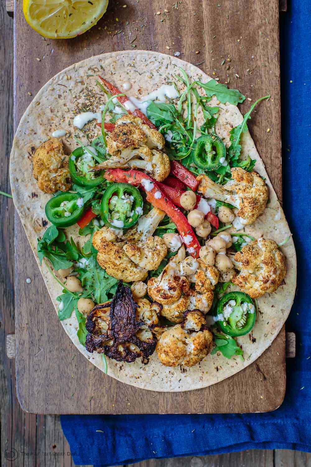 Mediterranean Vegan Wraps with Cauliflower and Tahini | The Mediterranean Dish. Satisfying vegan wraps with a Mediterranean twist. With za'atar roasted cauliflower, homemade tahini sauce, and a peppery arugula salad. A flavor-packed meatless dinner! See the recipe on TheMediterraneanDish.com