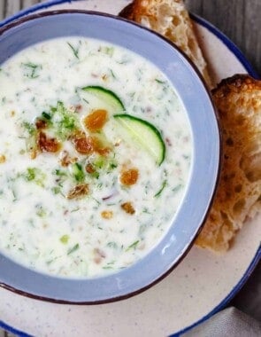 Persian Chilled Cucumber Soup (Abdoogh Kiar) | The Mediterranean Dish. A cold cucumber soup in a yogurt base with lots of fresh herbs, toasted walnuts, and raisins. Think detox soup to help you cool off and rest your body! See the recipe on TheMediterraneanDish.com