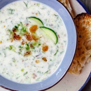 Persian Chilled Cucumber Soup (Abdoogh Kiar) | The Mediterranean Dish. A cold cucumber soup in a yogurt base with lots of fresh herbs, toasted walnuts, and raisins. Think detox soup to help you cool off and rest your body! See the recipe on TheMediterraneanDish.com