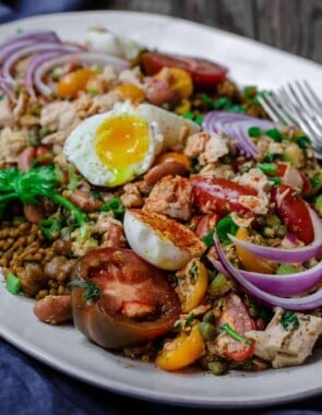 Tuna Couscous Salad Recipe | The Mediterranean Dish. Canned tuna takes on an Italian twist with kindey beans, fresh veggies, capers and more! Add heat and ready couscous pilaf from @wildgardenfoods for an easy weeknight dinner! See the full recipe on TheMediterraneanDish.com